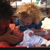 This gorgeous big sister is helping to calm her newborn sister! 