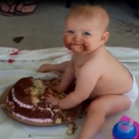 Little girl devouring her first ever cake, what a mess!
