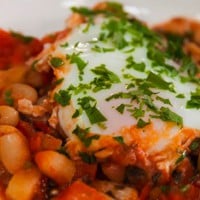 Baked eggs, cannellini beans and tomato