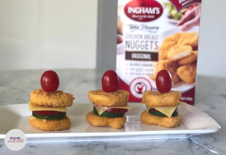 cute little mini burgers made of two inghams chicken nuggets with sliced cucumber tomato and cheese in between