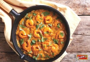skillet filled with delicious ayam prawn red curry and topped with chopped coriander