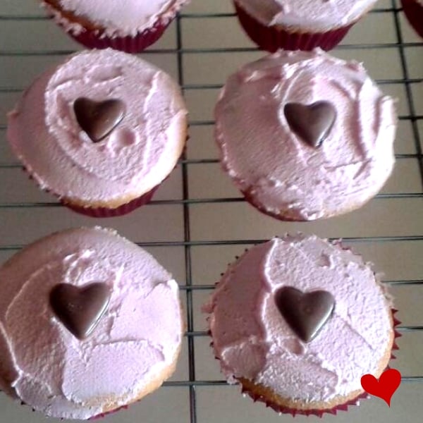Simple cupcakes with pink icing and a milk chocolate heart on top
