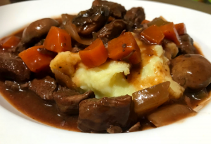 A yummy stew with mashed potatoes carrots and beef cooked in a nice red wine sauce