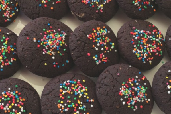 Dark chocolate chickpea and peanut butter cookies decorated with hundreds and thousands