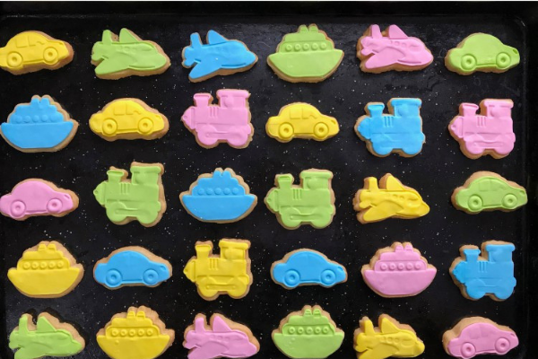 Small biscuits cut to the shape of planes, trains and automobiles covered in various coloured fondant