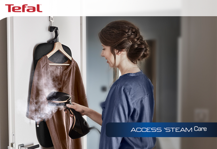 Woman with brown hair steaming a garment with a tefal handheld steameer
