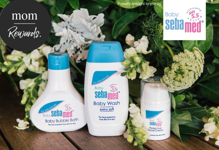 Sebamed products featured on a wodden table with lush green leaves and white flowers in the background
