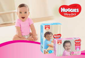 Photo of packs of New Improved Huggies Ultra Dry Nappies with a happy baby and the Huggies logo