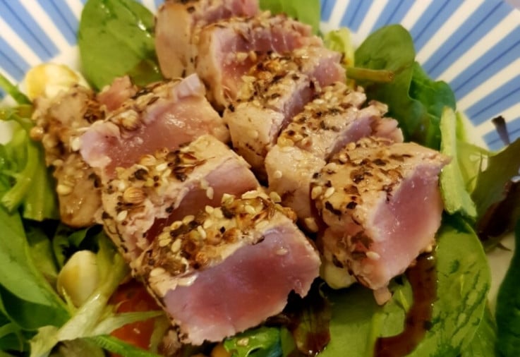 Seared Tuna Steak crusted in sesame seeds served on a bed of lettuce