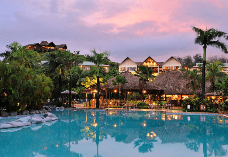 A sunset photo showing the pool and accommodation of the Outrigger resort in Fiji