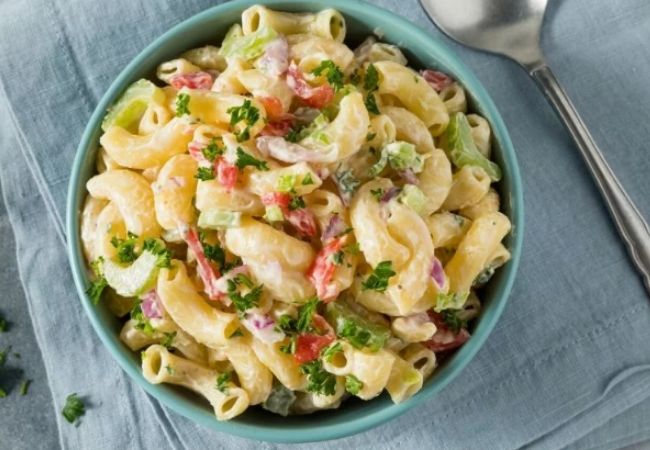 Salad Recipes_creamy pasta salad with lots of vegetables a creamy sauce served in a round green bowl