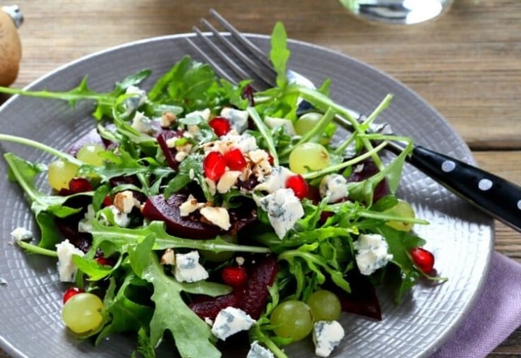 Pomegranate Salad with beetroot, fetta cheese and rocket served on a large grey plate