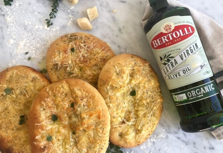 Focaccia Bread with Cheese made into individual loaves with a bottle of Bertolli Extra Virgin Organic Olive Oil alongside