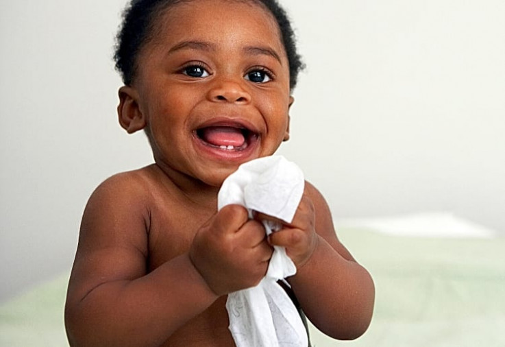image of baby holding wipe and smiling - Eco-Friendly Wipes For Baby Do Exist And We've Found The Best