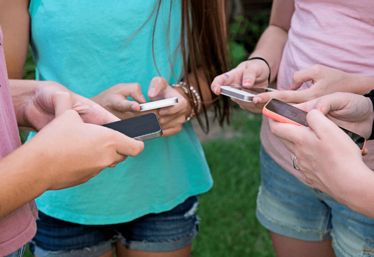 Teen girls with phones_main image_750x516