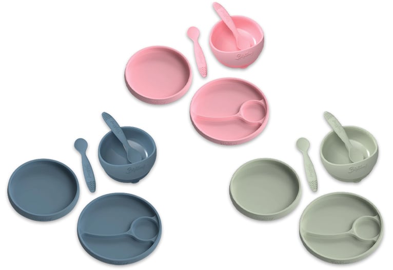 Three silicone baby feeding sets in blue, green and pink.lours.