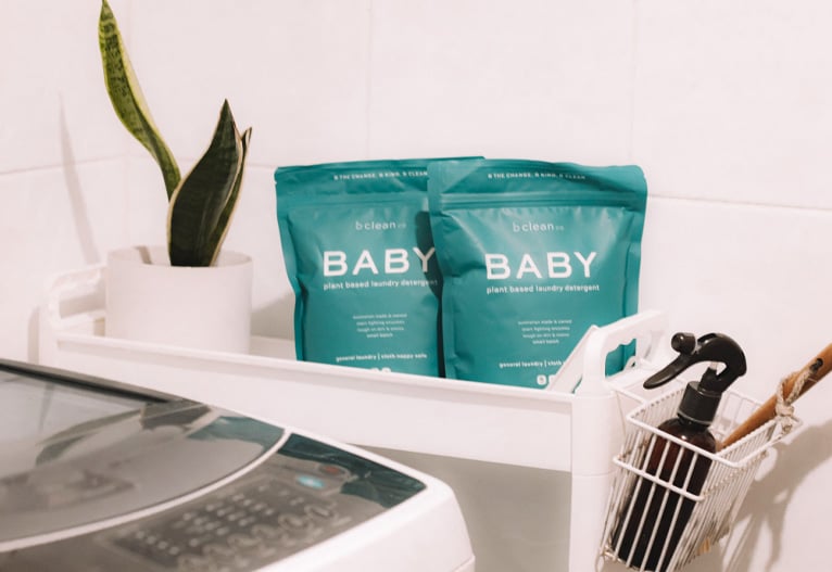 be clean co Baby Laundry Detergent on shelf next to washing machine.