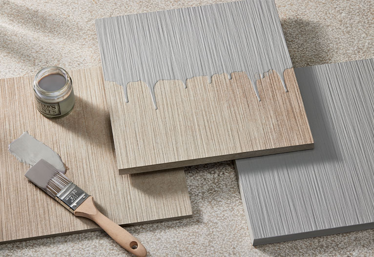 Half-painted samples of concrete cladding shown with a paintbrush and pot.