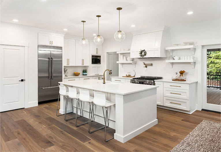 White Hamptons-themed kitchen with wooden floors.