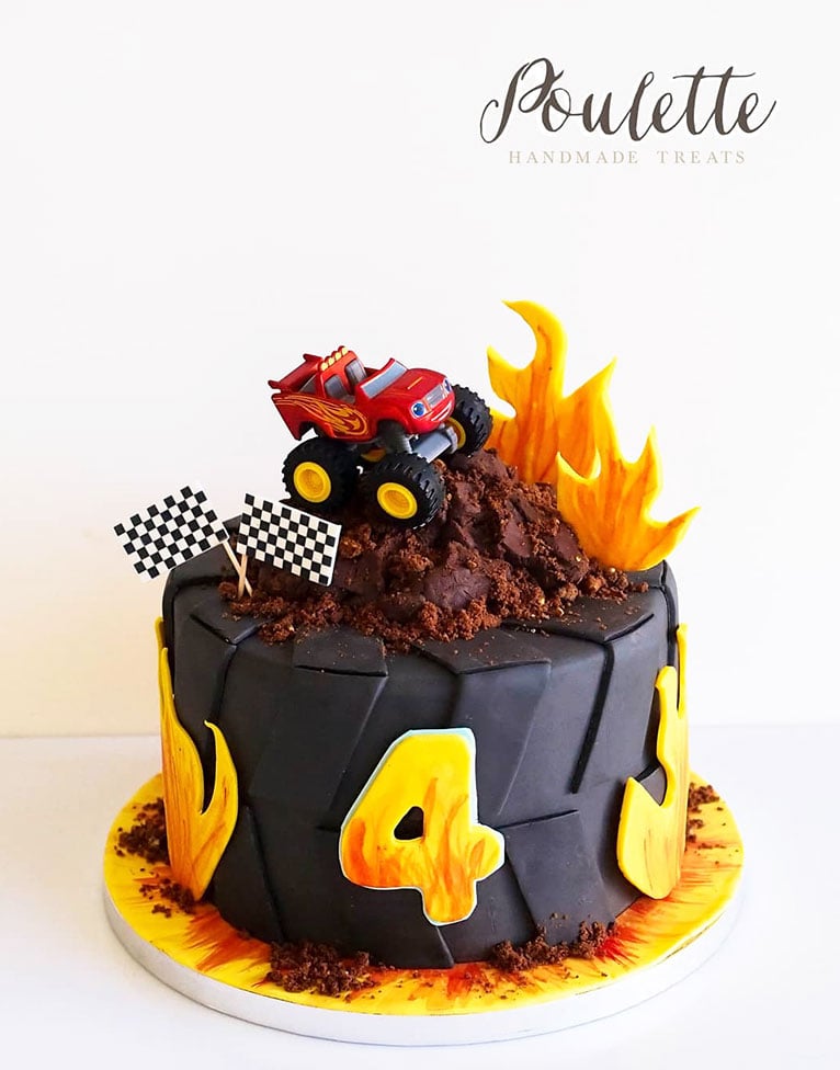 Black and yellow birthday cake shaped like a tyre with a red truck on top.