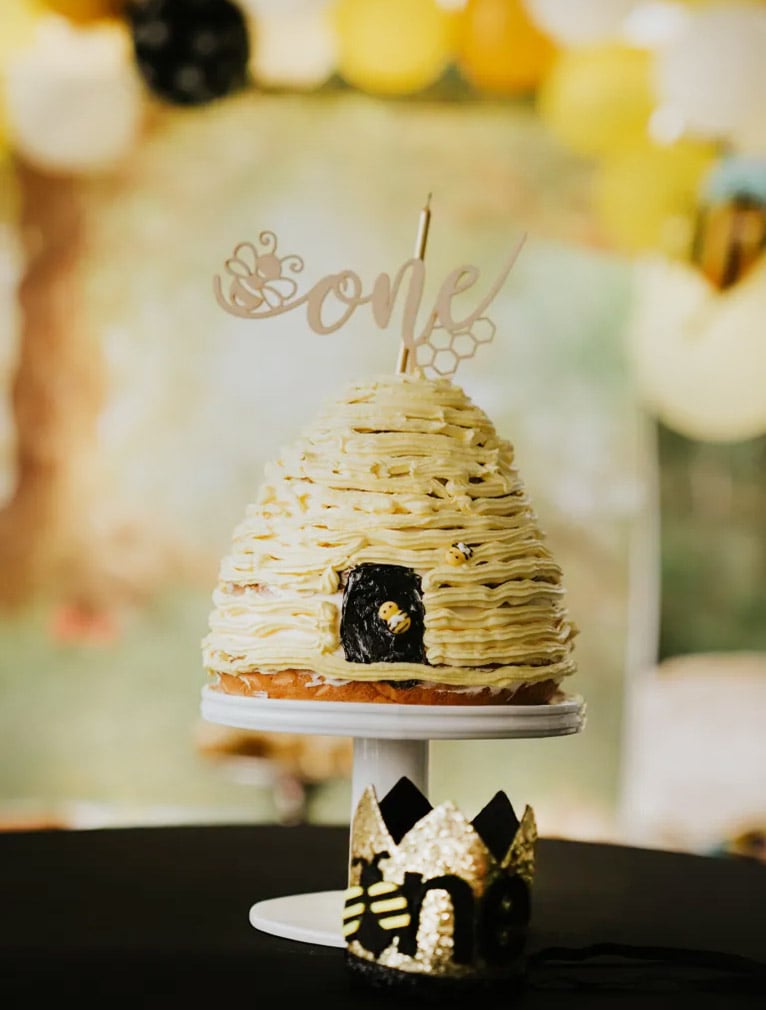 Yellow beehive cake with a little black door painted on the front.