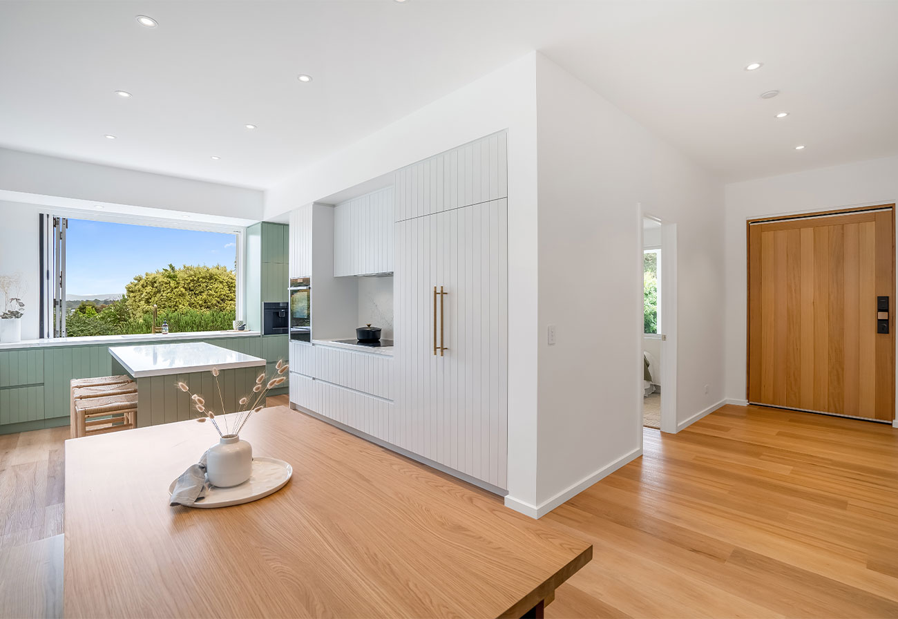 Entry and kitchen of a modern home with timber floors.