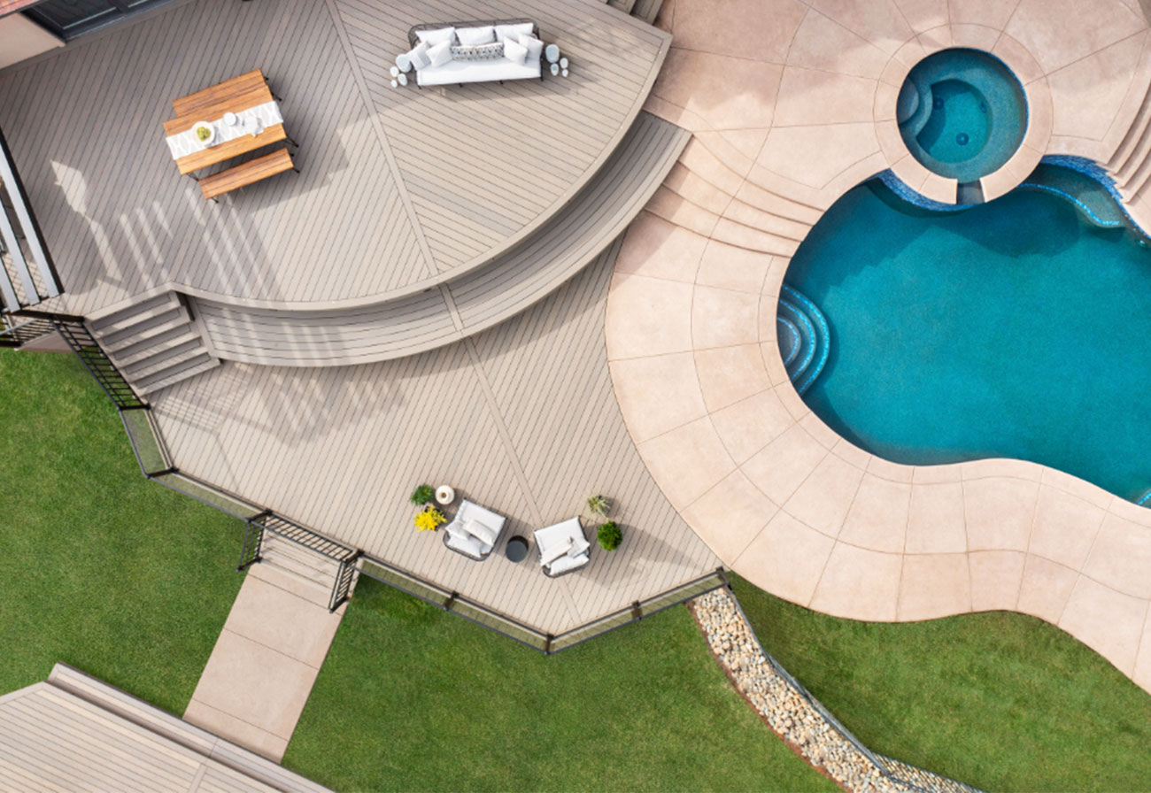 Backyard swimming pool surrounded by multi-level composite decking.