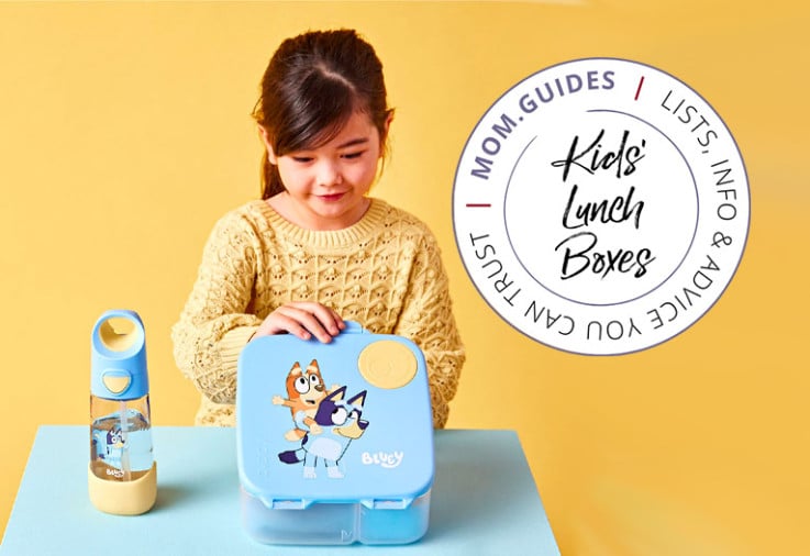 A girl sitting at a table with a b.box bento lunch box..