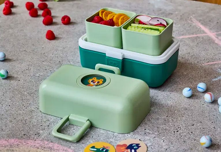 Forest green Monbento Tresor lunch box on a table.