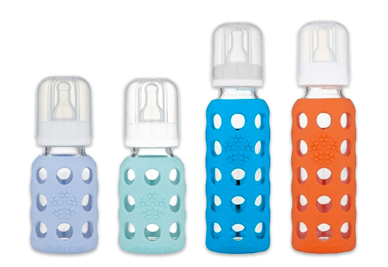 Four Lifefactory glass baby bottles in a row.