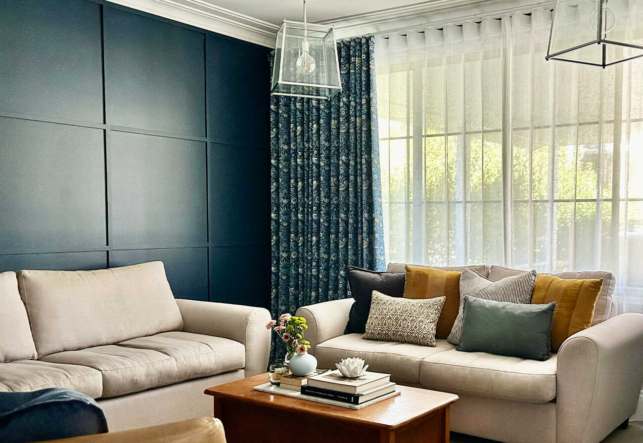 Living room with navy walls and blue curtains.