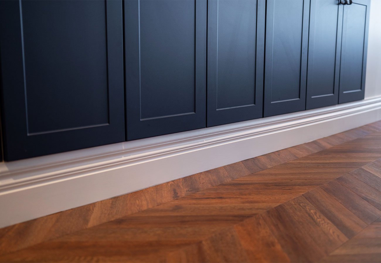 Hume skirting boards under a navy sideboard.