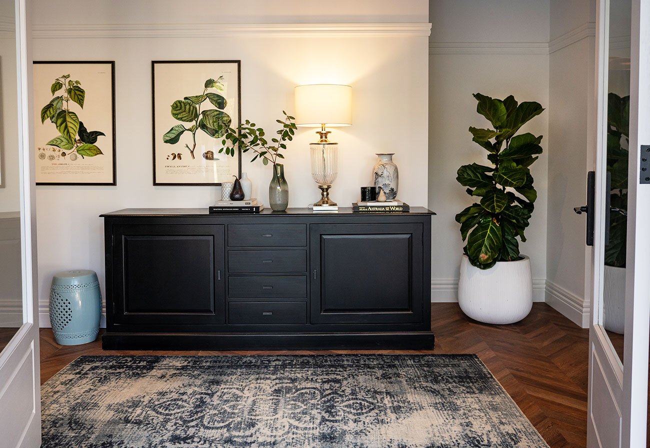 Entrance with black console and botanical prints.