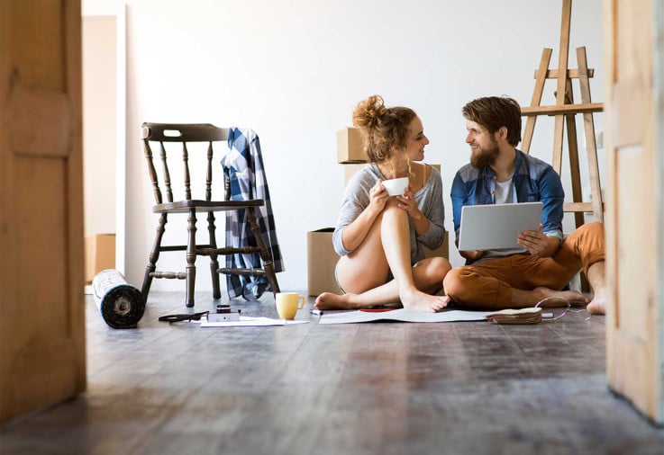 Couple sitting on floor amid renovation.