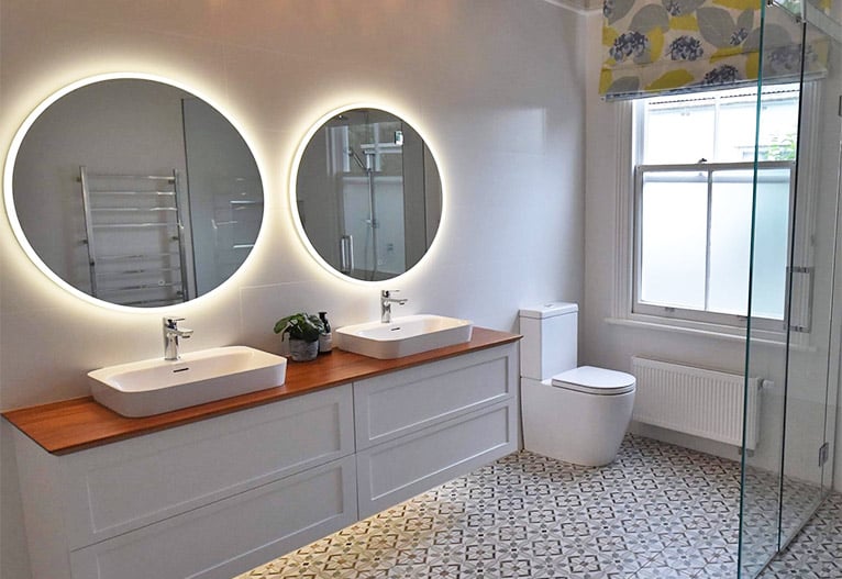 Two round LED mirrors in a bathroom.