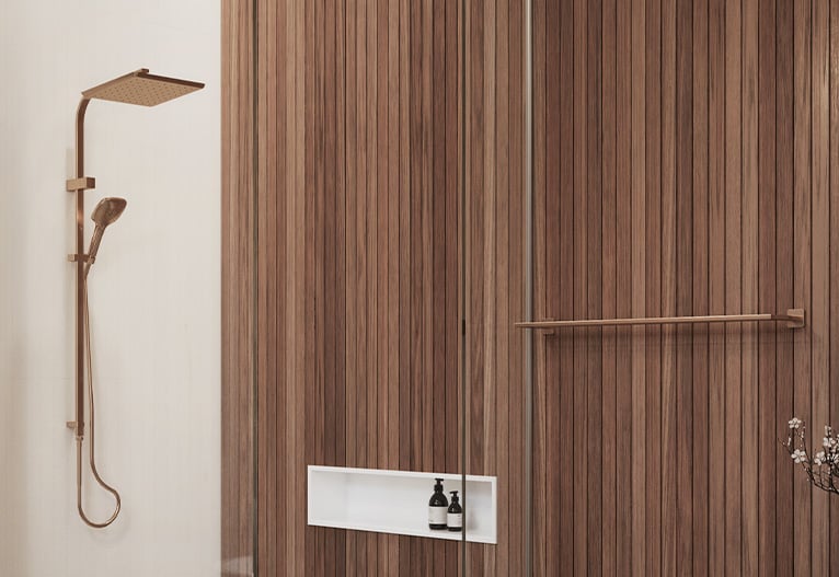 Shower cubicle with wood panelling and brushed copper shower rail.