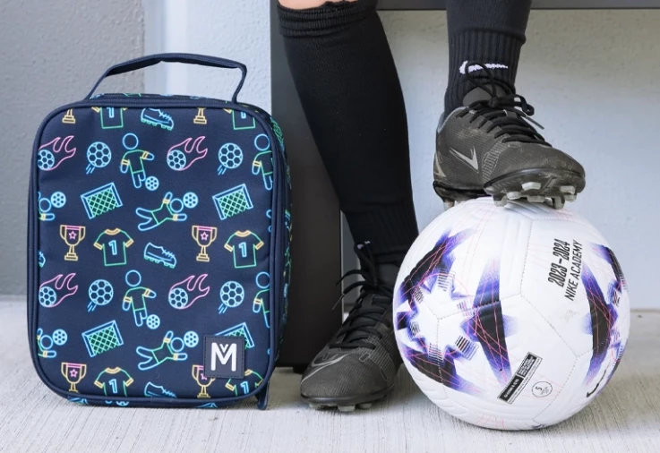MontiiCo large lunch bag next to a boy and his soccer ball.