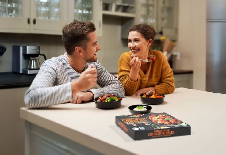 Couple eating dinner in kitchen.