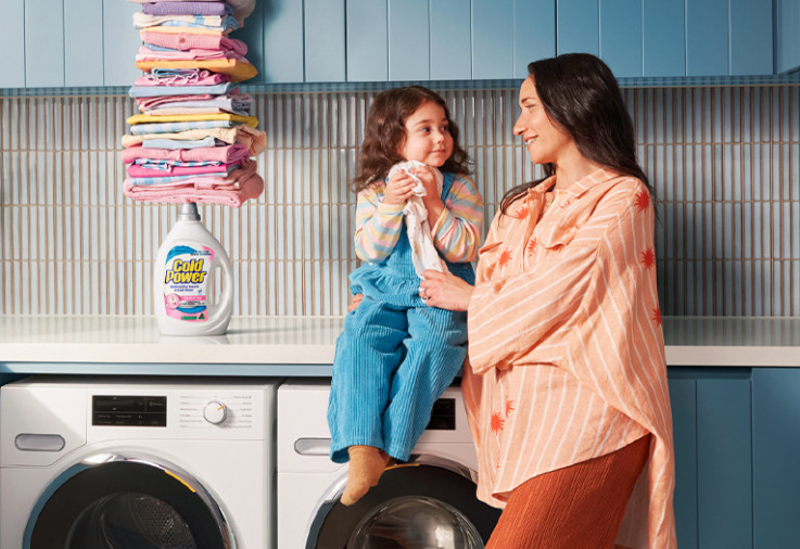 Woman and child in a laundry with Cold Power Sensitive detergent.
