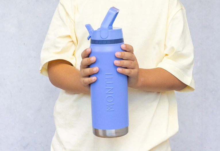 Boy holding a blue MontiiCo Sport insulated drink bottle.