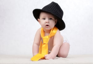 Baby boy in a hat and tie.