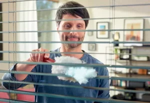 Man using the Vileda Flex & Catch Duster on blinds.